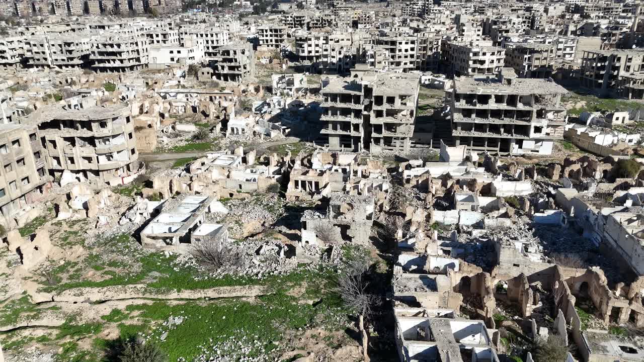 Ripresa aerea con drone che mostra l'estesa distruzione bellica e gli edifici in rovina nel quartiere di Jobar a Damasco, Siria.