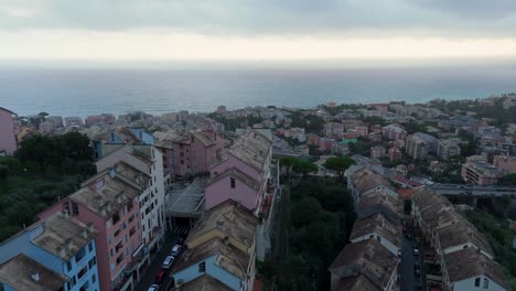 pastel-colored buildings on a coastal town in italy under a cloudy sky, aerial view