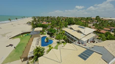 proximity drone shot over a resort towards the tropical beach in brazil.