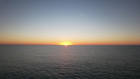 the setting sun with its bright yellow light created a stunning view on the horizon over the water surface heated by the hot rays