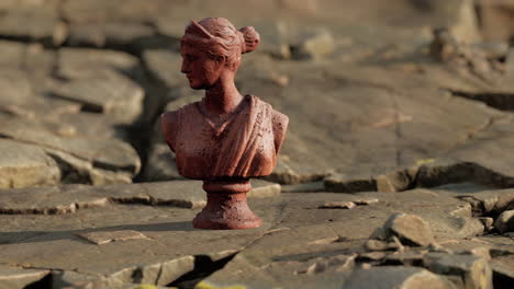 ancient-statue-of-woman-on-rocky-stones