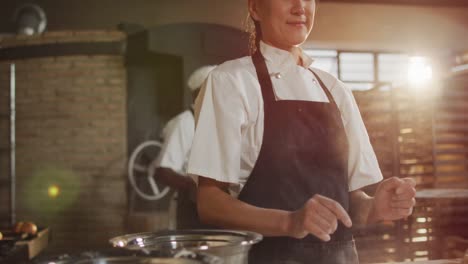 Animation-of-happy-asian-female-baker-clapping-hands-to-clean-flour