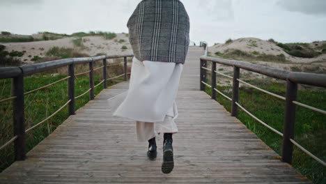 stylish legs walking wooden pathway. casual serene woman thinking life going