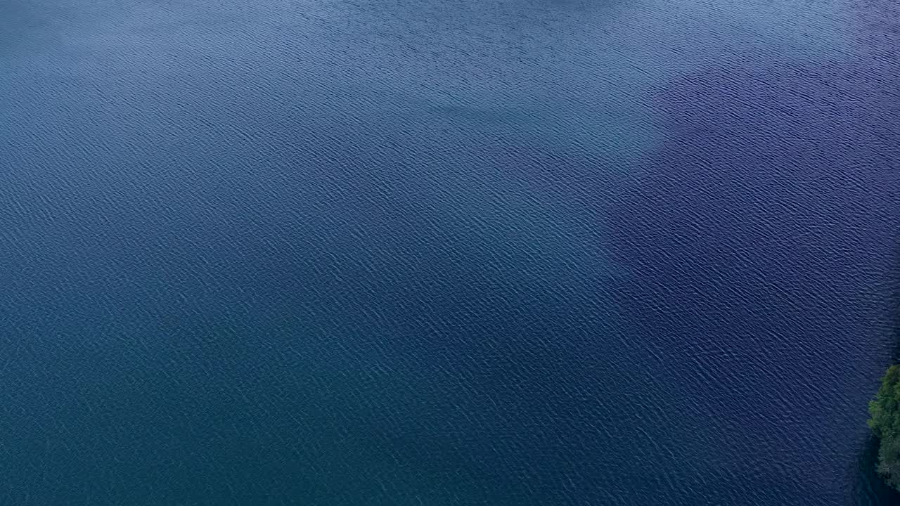 Ripresa aerea con drone da alta angolazione scivola sopra acqua turchese profonda e rigogliose scogliere calcaree di isole