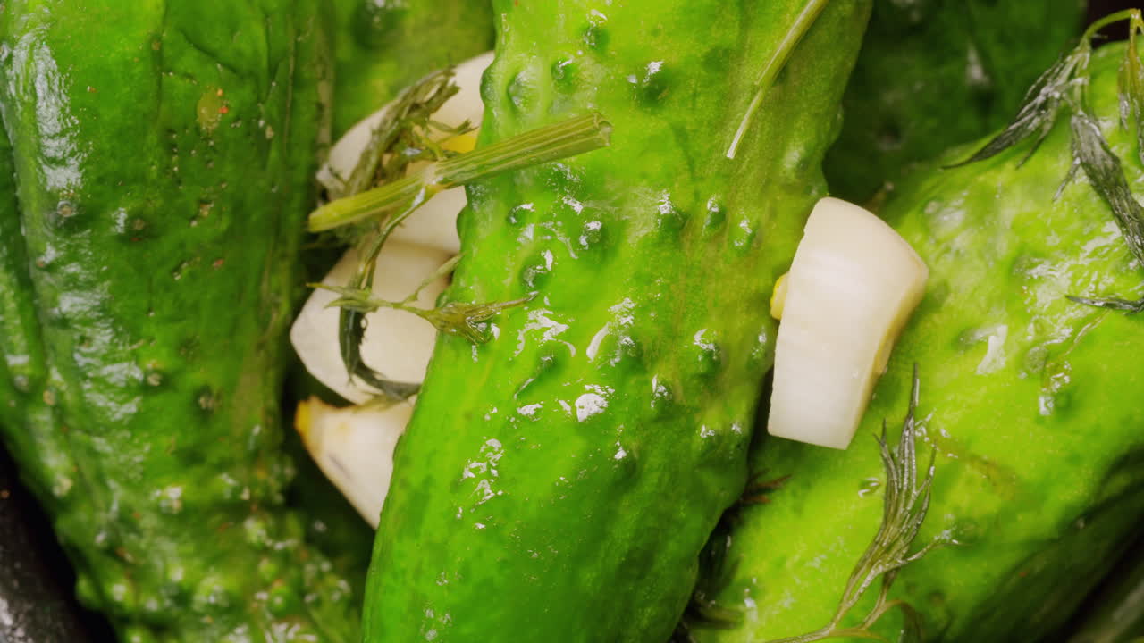Close-up of fermented cucumbers with garlic and dill on plate. Preservation of vegetables in glass jars. Fermentation preserved cucumbers with spices. Russian cuisine.