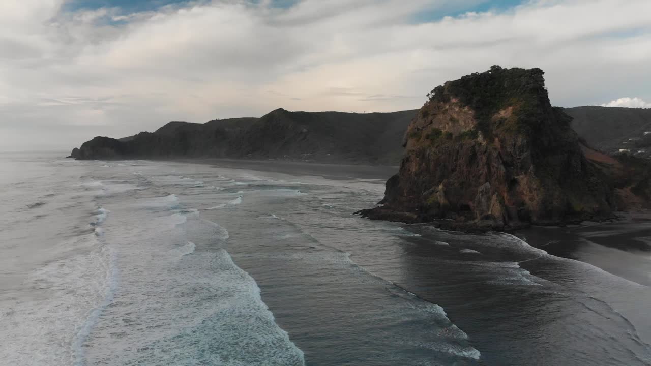 toma aérea con drones de la playa de piha y la roca del león en nueva zelanda