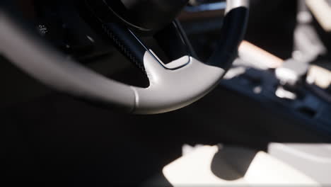 closeup of a black leather steering wheel in a car interior