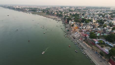 aerial view of the ganga river in banaras, with colorful boats and temples lining the riverbanks.