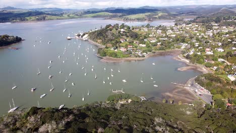 una toma aérea de aviones no tripulados de la ciudad de mangonui, el puerto y los barcos en la bahía indudable en northland, nueva zelanda, aotearoa