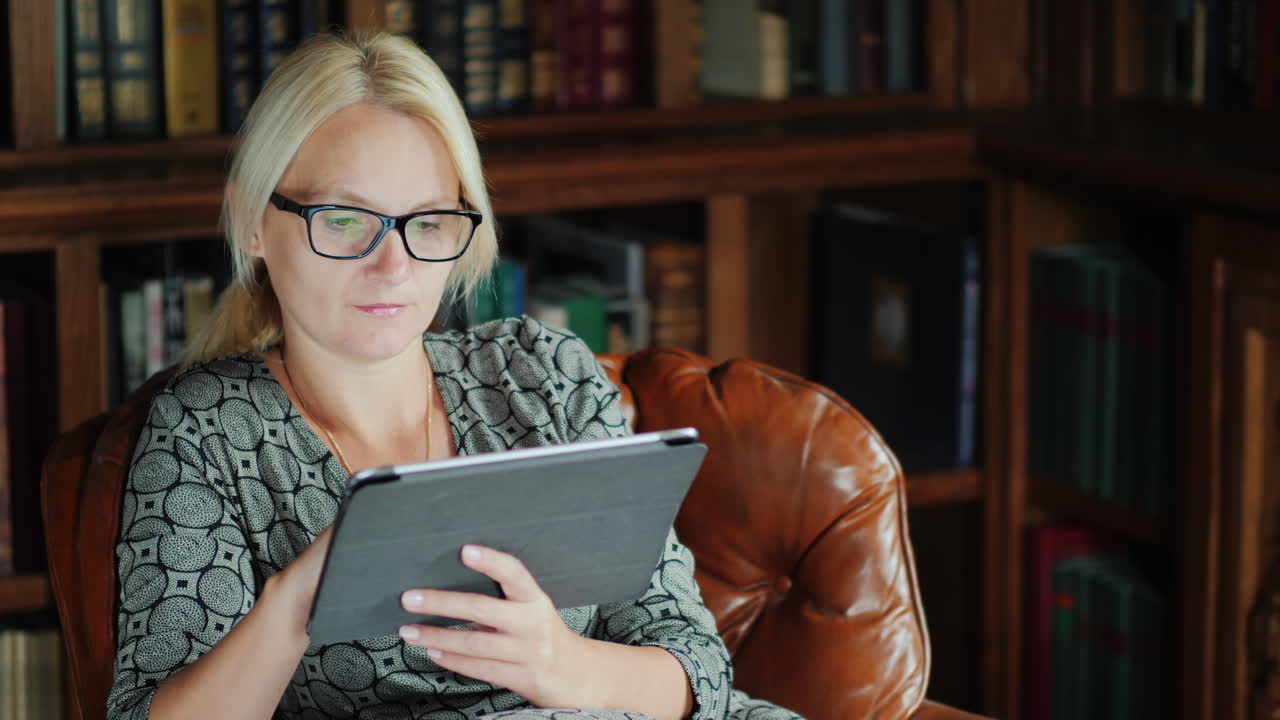 mujer en silla de cuero usando tableta