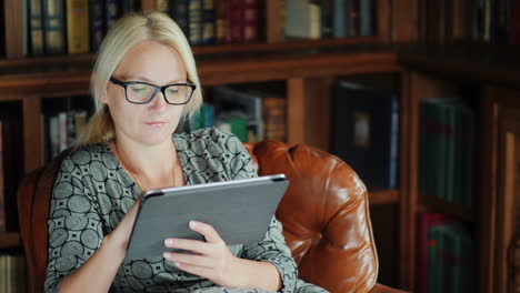 Frau-Im-Ledersessel-Mit-Tablet