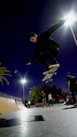 young skateboarder performing tricks at night in a skatepark