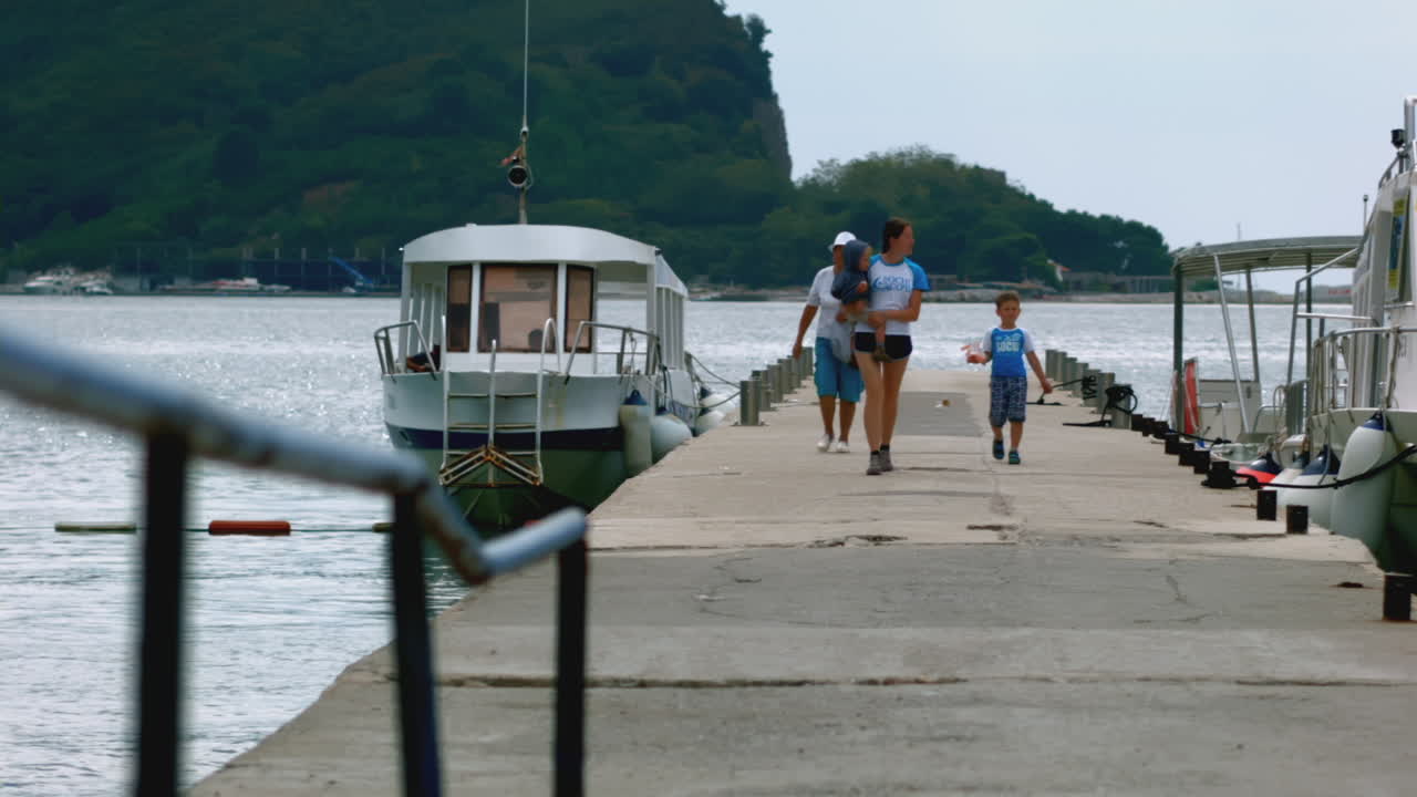 familia caminando en el muelle junto al río