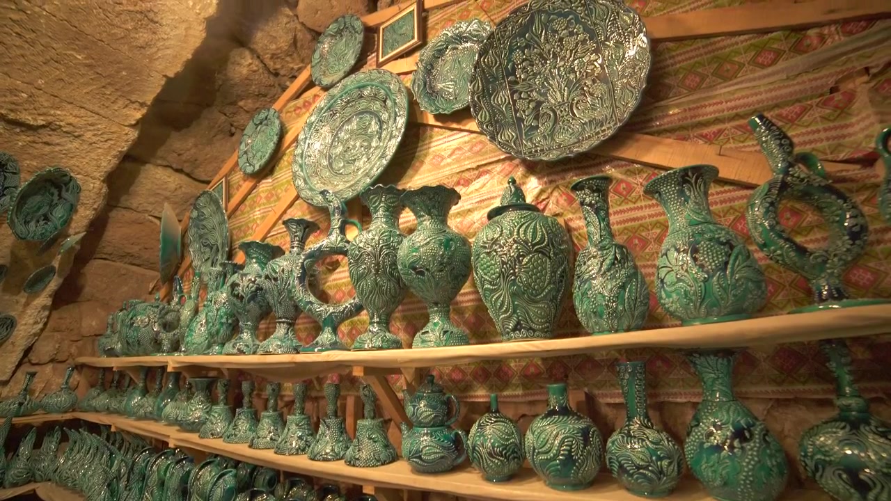 Ceramica turchese artigianale tradizionale esposta su scaffali di legno