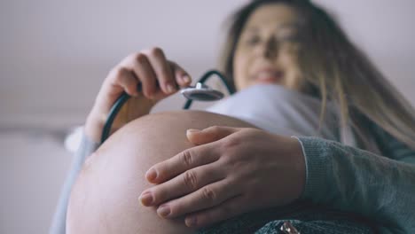 Schwangere-Frau-Berührt-Babybauch-Mit-Stethoskop-In-Nahaufnahme