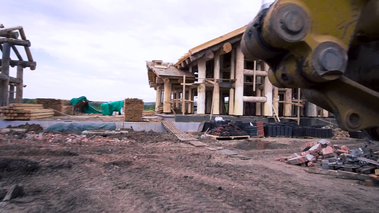 Log Cabin Construction Site with Excavator