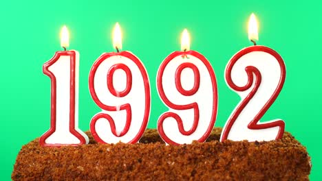 pastel con el número 1992 vela encendida fecha del siglo pasado llave de croma pantalla verde aislado