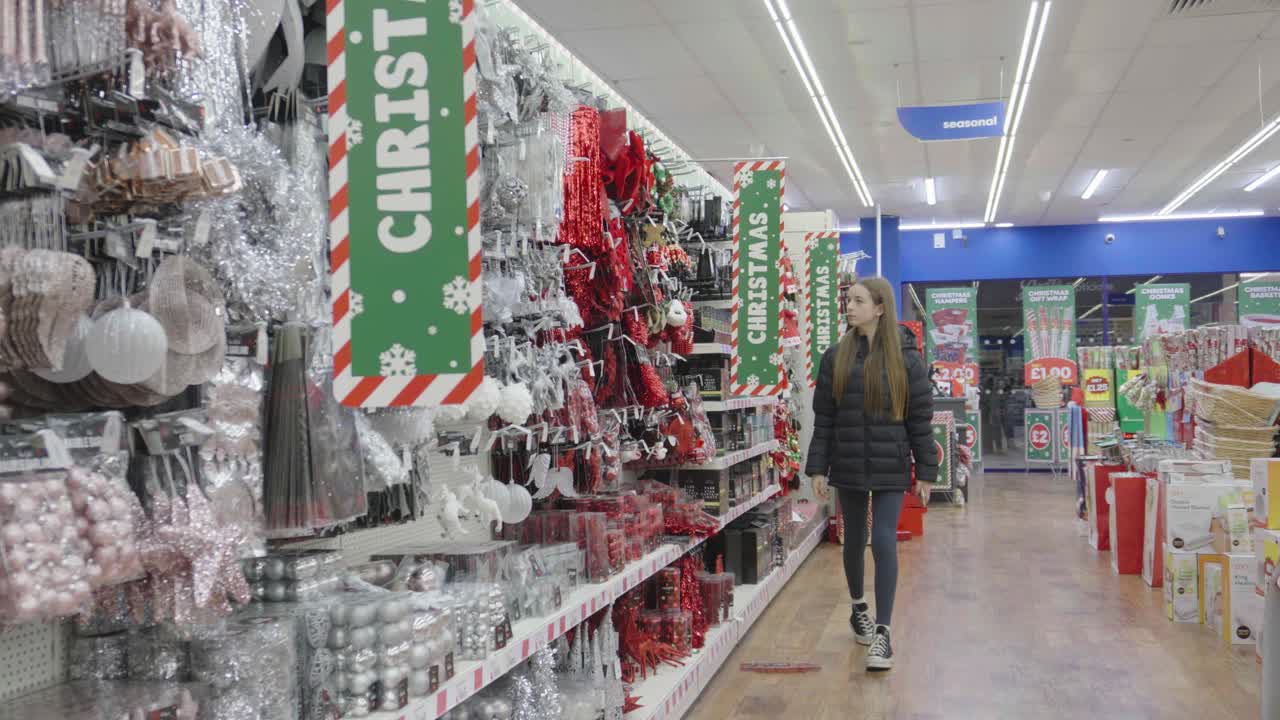tienda que muestra decoraciones de árboles de navidad como jóvenes adolescentes navega