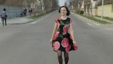 Attraktive-Junge-Frau-In-Einem-Kleid-Mit-Blumen-Zu-Fuß-Auf-Der-Autobahn