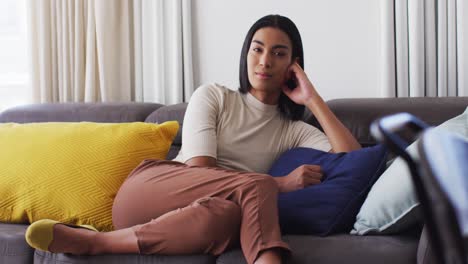 portrait of gender fluid male smiling while sitting on the couch at home