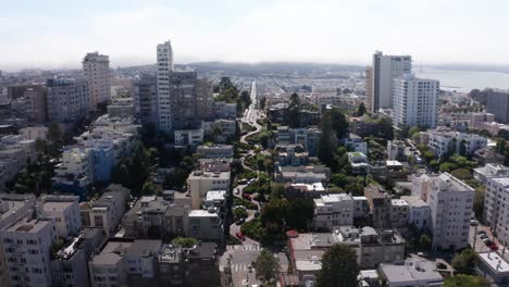 descendiendo disparo aéreo de cerca de los coches que van por la famosa calle torcida de lombard en la colina rusa en san francisco, california