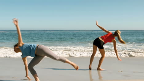 attractive women doing cartwheels in front of the sea