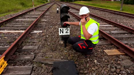 worker on walkie talkie near broken warning beacon