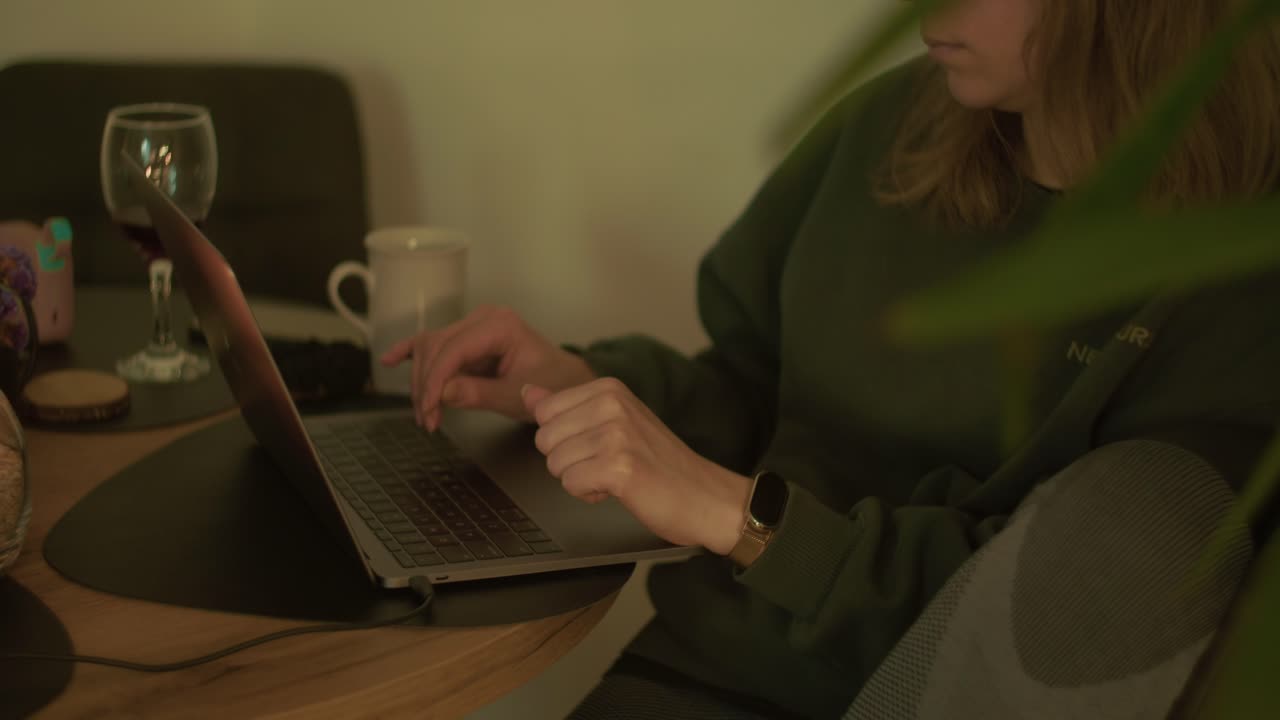 Woman working online from home office with laptop and tea