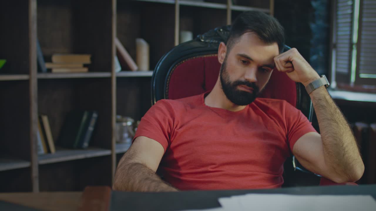 Upset businessman sitting in office at evening. Sad businessman thinking