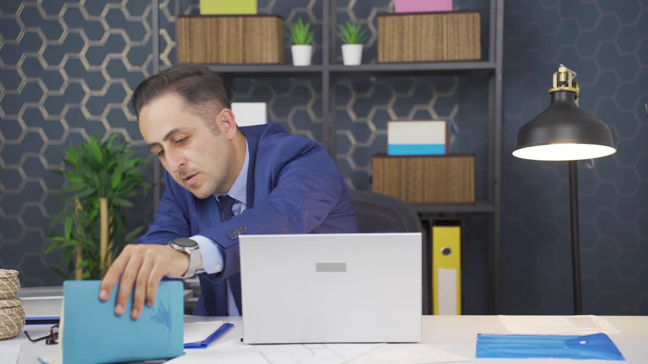 hombre de negocios buscando documentos en la mesa.