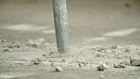 close-up of excavator hydraulic arm rock breaker working on concrete road.slow motion
