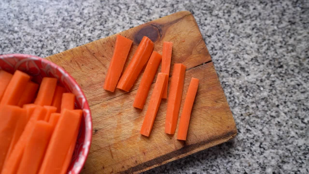 Zanahorias cortadas en bastones sobre tabla de madera