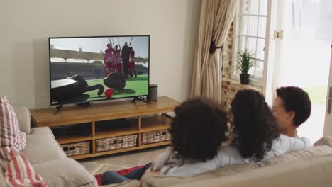 Composite-of-happy-family-sitting-at-home-together-watching-hockey-match-on-tv