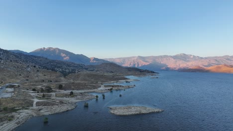 Sonnenuntergang-über-Dem-Lake-Isabella-In-Kalifornien-Mit-Touristenverkehr-Im-Blick,-Dynamische-Schatten-Durch-Die-Berge,-60 fps