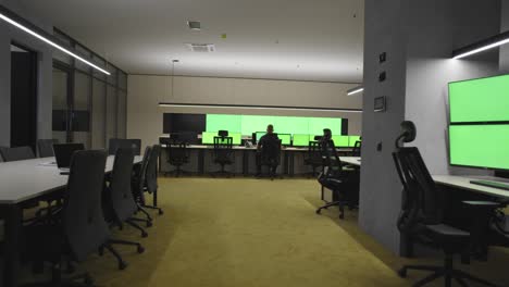 empty office, desk, and chairs at a main cctv security data center with green screen and chroma key