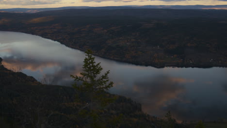 Aerial,-panoramic-view-of-a-quiet-lake,-with-a-pan-to-an-extended-view-in-the-distance