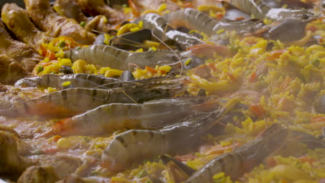 close up shot of the tiger shrimps on a big paella plate with lots of calamari and chicken legs