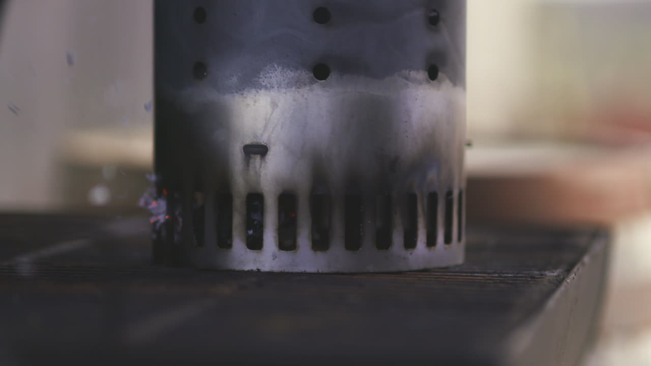 разогрев и пламя угольного дымохода на гриле во время барбекю в общественном парке летом