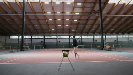 man playing tennis in an indoor court