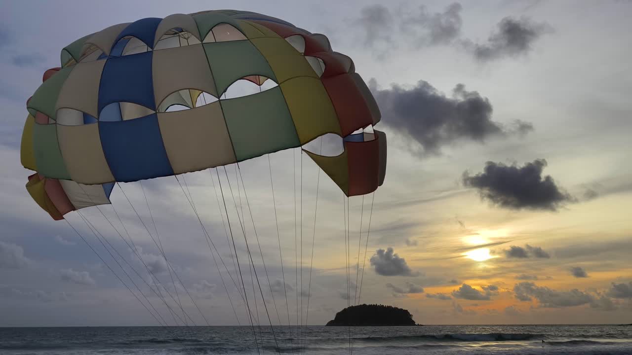 parasailing al atardecer sobre la playa del océano