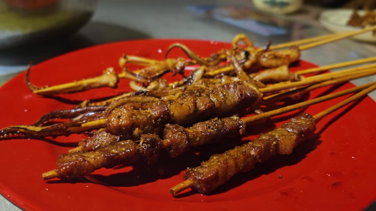 Hands lifting octopus sticks street food on a plate in Yangshuo, China