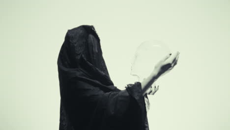 mysterious woman holding a transparent skull
