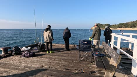 group of fishermen casting lines on pier