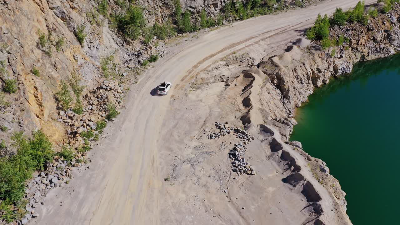 Car driving near lake. View of the road near lake and mountain from above