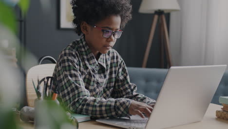 child working on a laptop at home