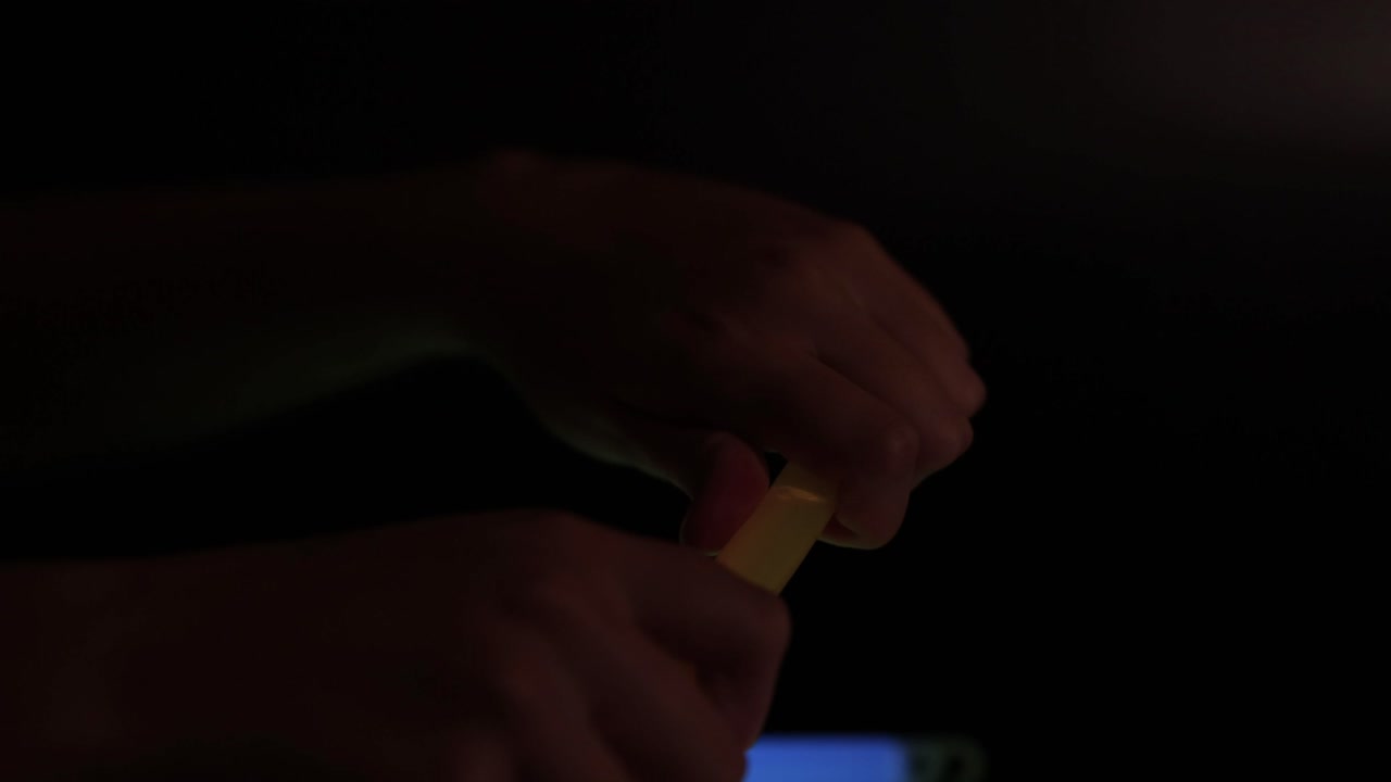 Mani che attivano uno stick luminoso giallo
