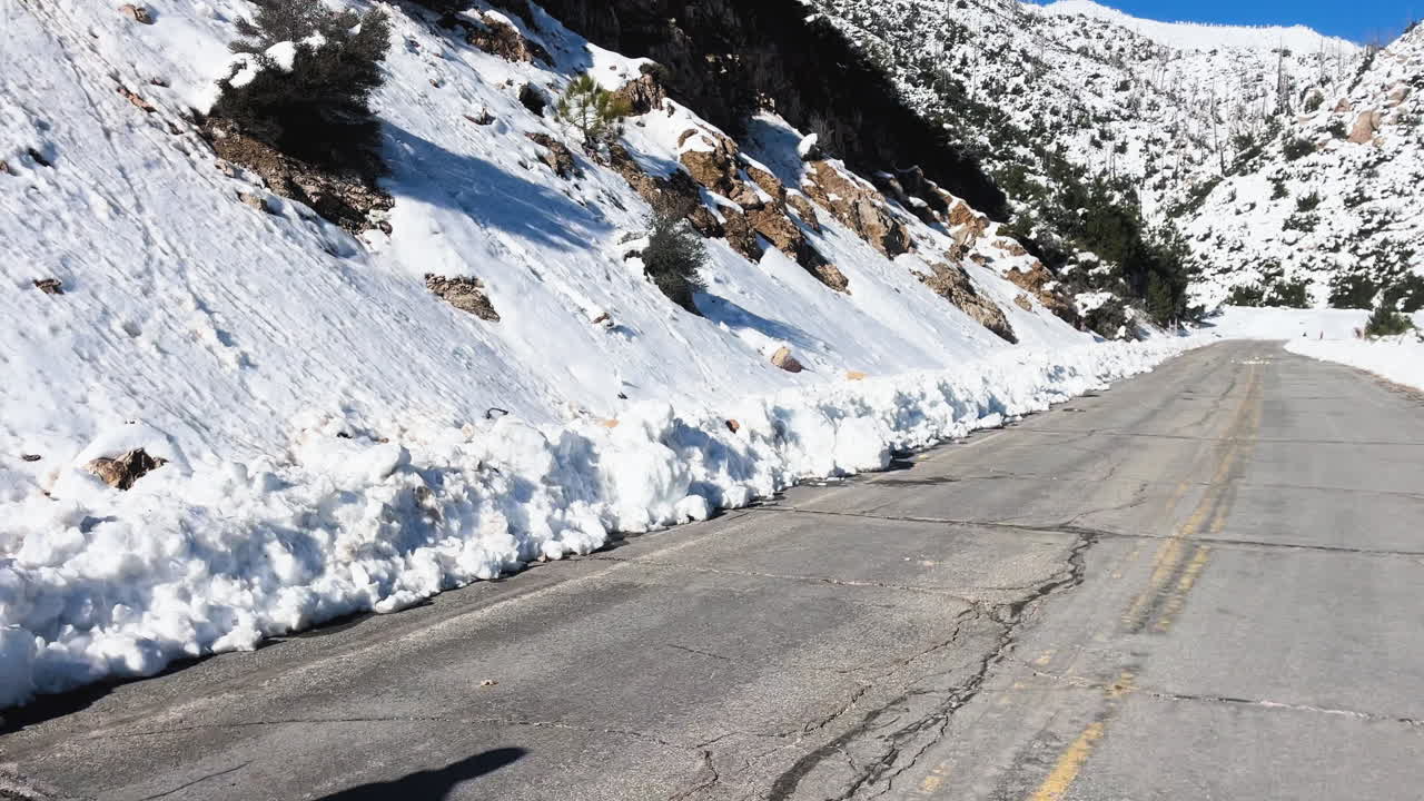 Man cycling on snowy mountain road, snow scene in mountains, cold winter environment