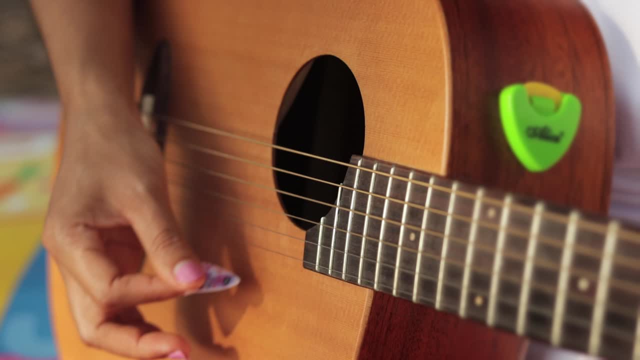 primer plano de manos femeninas punteando cuerdas de guitarra
