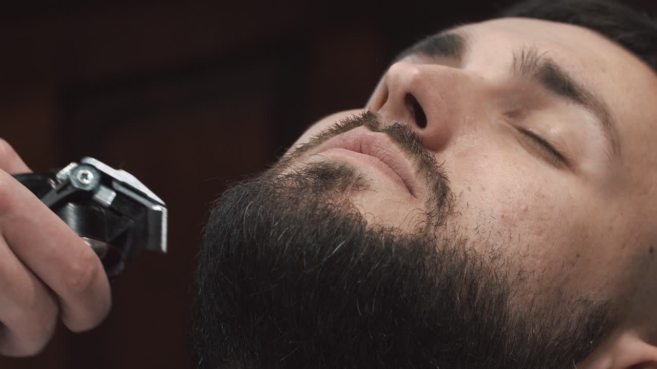 Barber klipper en mands skæg