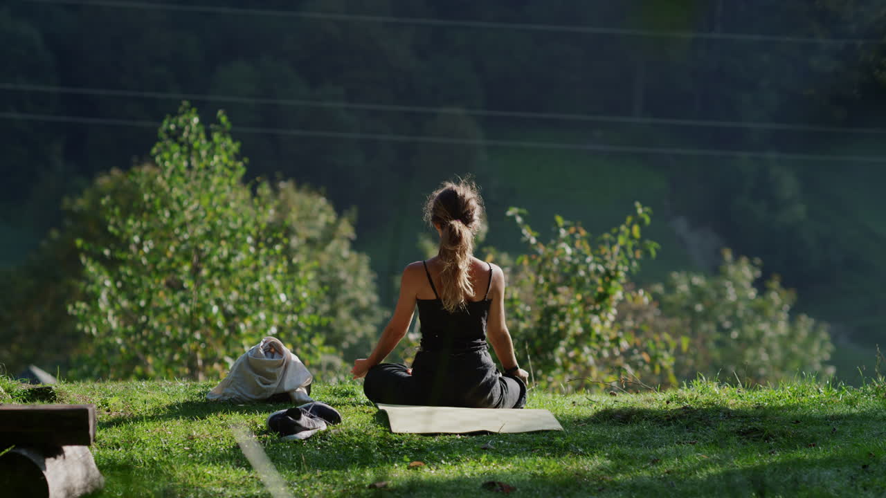 Young woman meditating in yoga pose on a summer morning outdoors